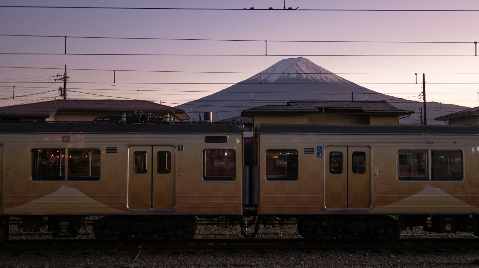 昼の線路を走るベージュ色の電車